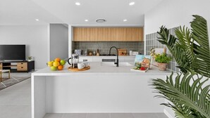 Una cocina moderna con una isla central, horno empotrado y un amplio ventanal sobre el fregadero.