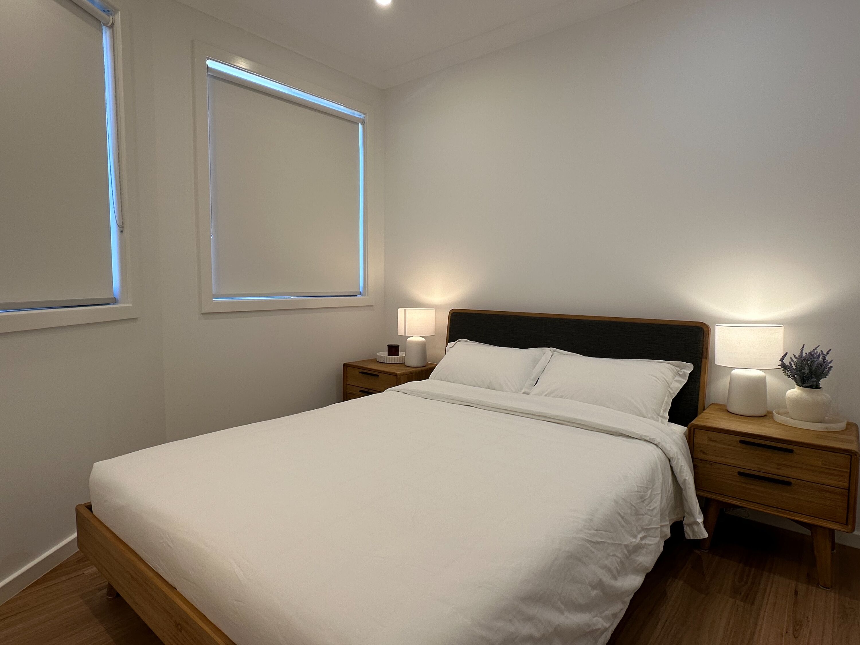 Una camera da letto con un letto, comodini, lampade da comodino e una finestra.