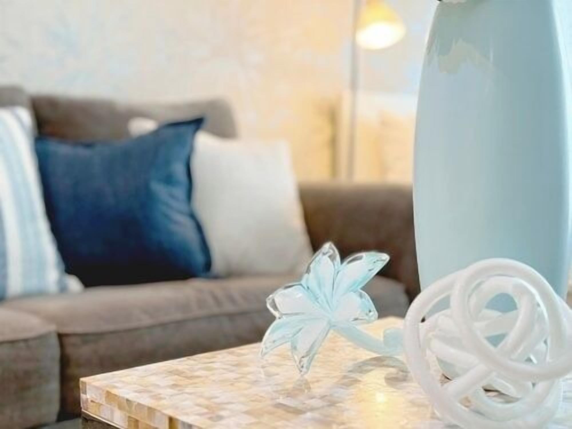 A room with a wooden coffee table, a white decorative item, and a white cable.