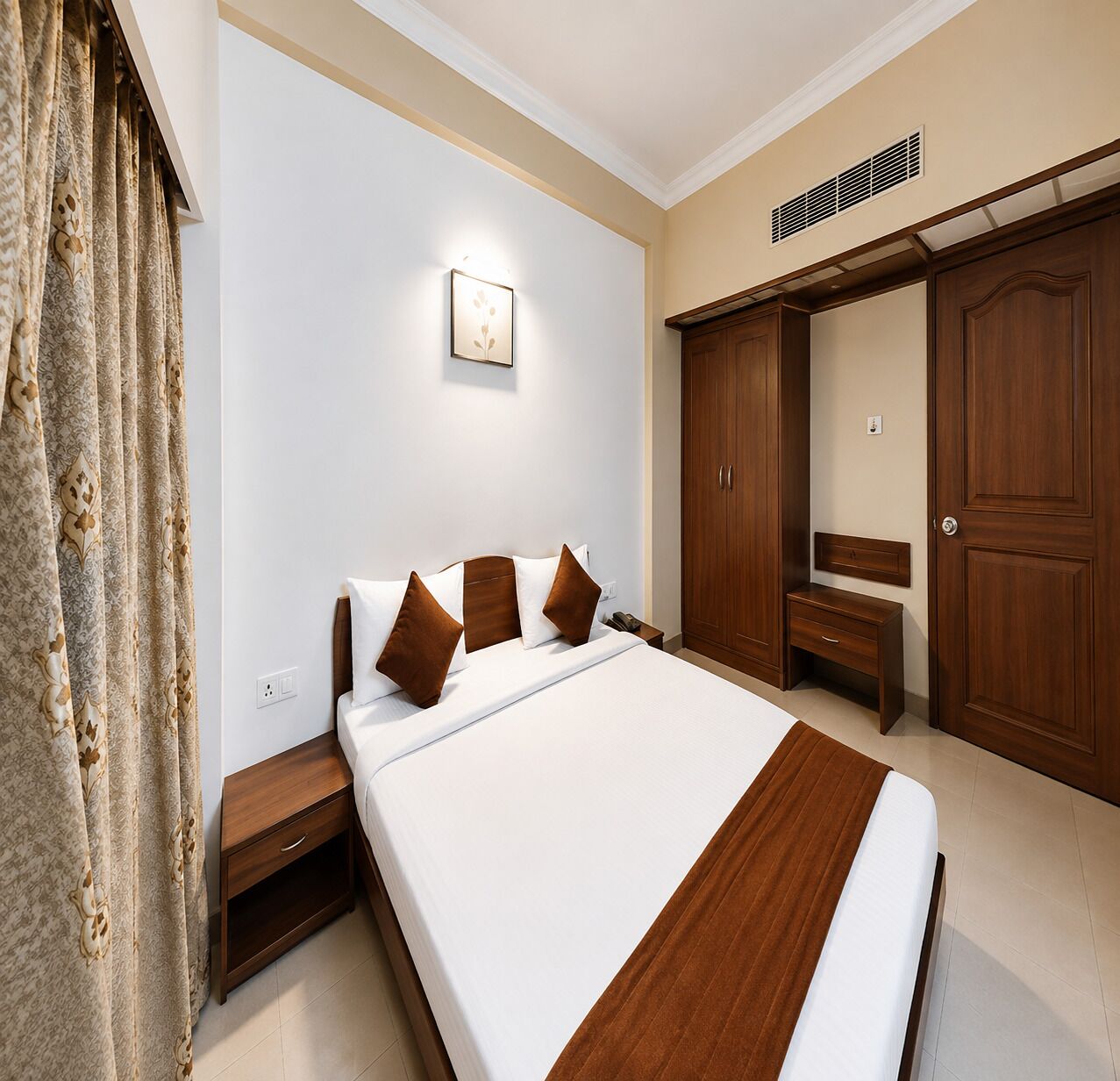 Habitación de hotel con cama, mesita de noche, armario y espejo.