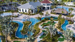 A resort with multiple swimming pools, palm trees, and a building with a red roof.