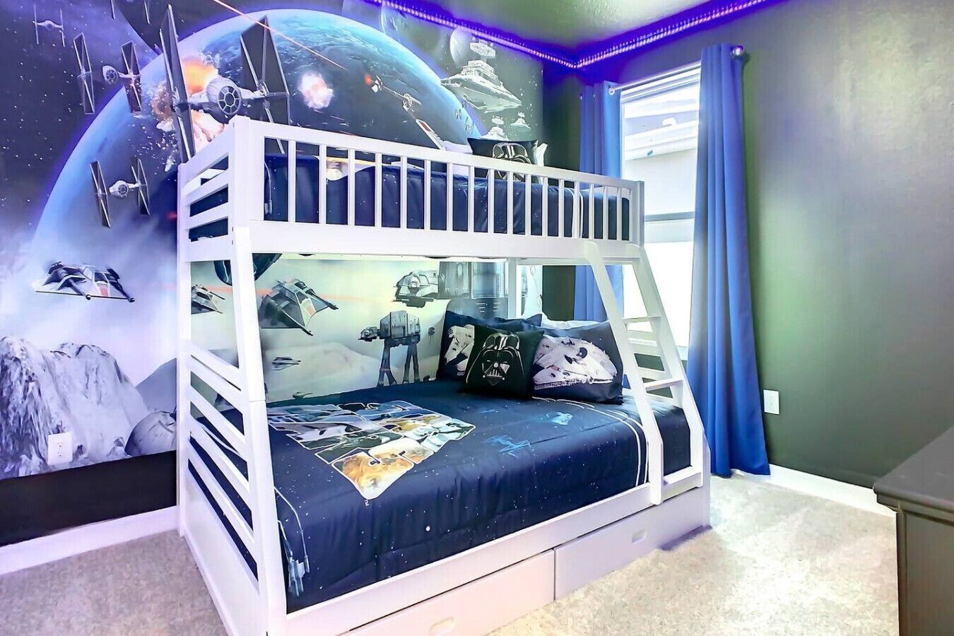 A bunk bed with a Star Wars-themed wall mural, a window with curtains, and a carpeted floor.