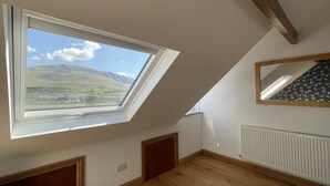 A room with a skylight, wooden floors, a radiator, and a mirror on the wall. - Ruby's Cottage -  a house that sleeps 4 guests  in 2 bedrooms (Threlkeld)