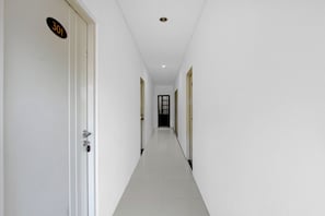 A corridor with white walls and doors, one marked with the number '301'.