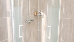 A glass-enclosed shower stall with a handheld showerhead and a handheld faucet. - Appartement 6 personnes  – Châtellerault (Châtellerault)