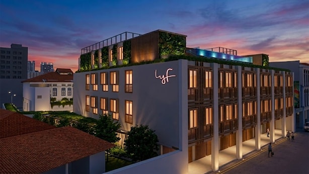 A modern hotel with a rooftop garden, multiple balconies, and a neon sign. - lyf Chinatown Singapore (Singapore)