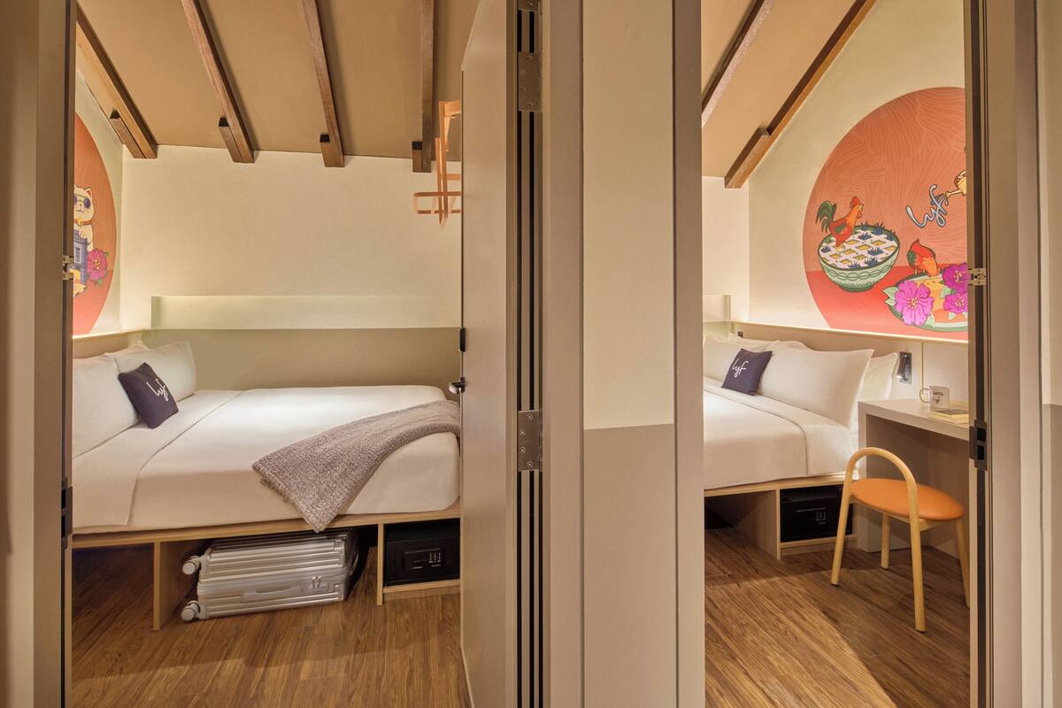 Een moderne slaapkamer met een bed, nachtkastje, stoel en een wand met decoratief ontwerp.