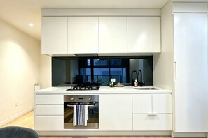 Oven, stovetop, cookware/dishes/utensils, dining tables - Free Tram Zone - Lighthouse Apt near Vic Market (Melbourne)