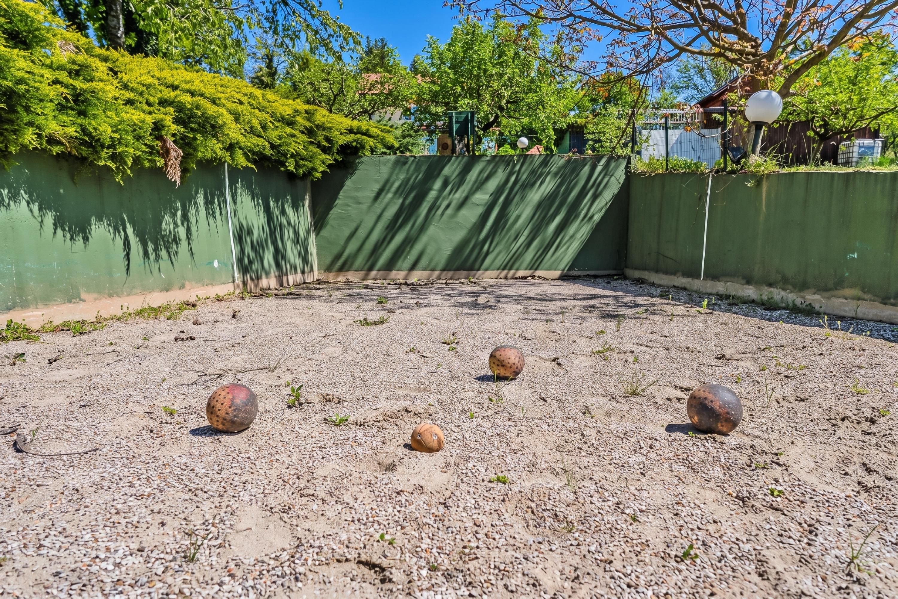 Un espace extérieur doté d’un sol en gravier et d’un mur végétal.