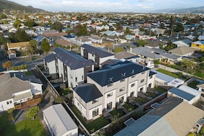 A residential area with modern houses, including a large two-story building with a flat roof and multiple windows.