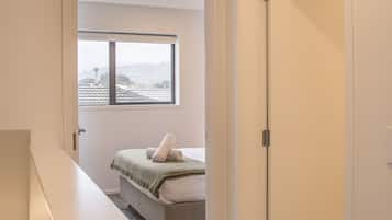 A bedroom with a bed, a window, and a door.