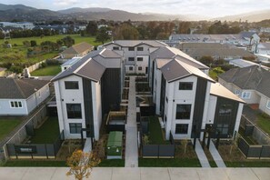 A residential complex with modern architecture, featuring multiple two-story buildings with flat roofs and large windows.