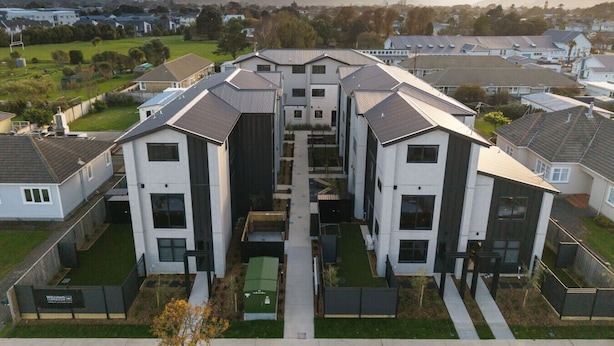 A residential complex with modern architecture, featuring multiple two-story buildings with flat roofs and large windows. - Modern 1BR Townhouse with Private Courtyard (Lower Hutt)