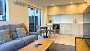 En moderne stue med sofa, sofabord og spiseområde.
