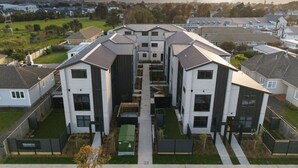 A residential complex with modern architecture, featuring multiple two-story buildings with flat roofs and large windows. - Bright & Spacious Wellington Townhouse (Lower Hutt)