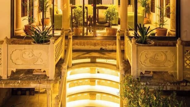 A building with a central staircase, large glass doors, and columns. - Rudreshwar Mahadeo Kothi (Varanasi)