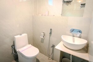 A bathroom with a toilet, a sink, and a shower.