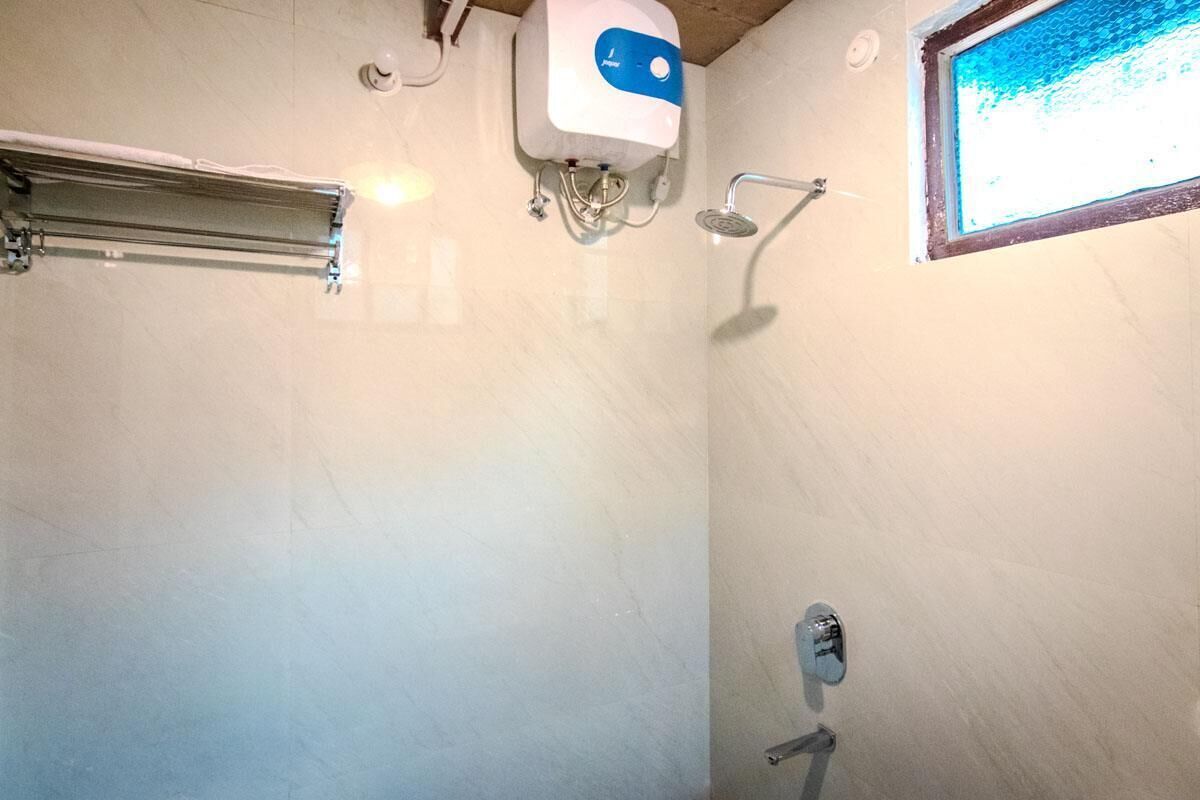 Un baño con ducha, toallero y ventana.