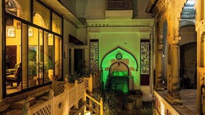 A courtyard with a fountain, a staircase, and a building with ornate architecture. - Rudreshwar Mahadeo Kothi (Varanasi)