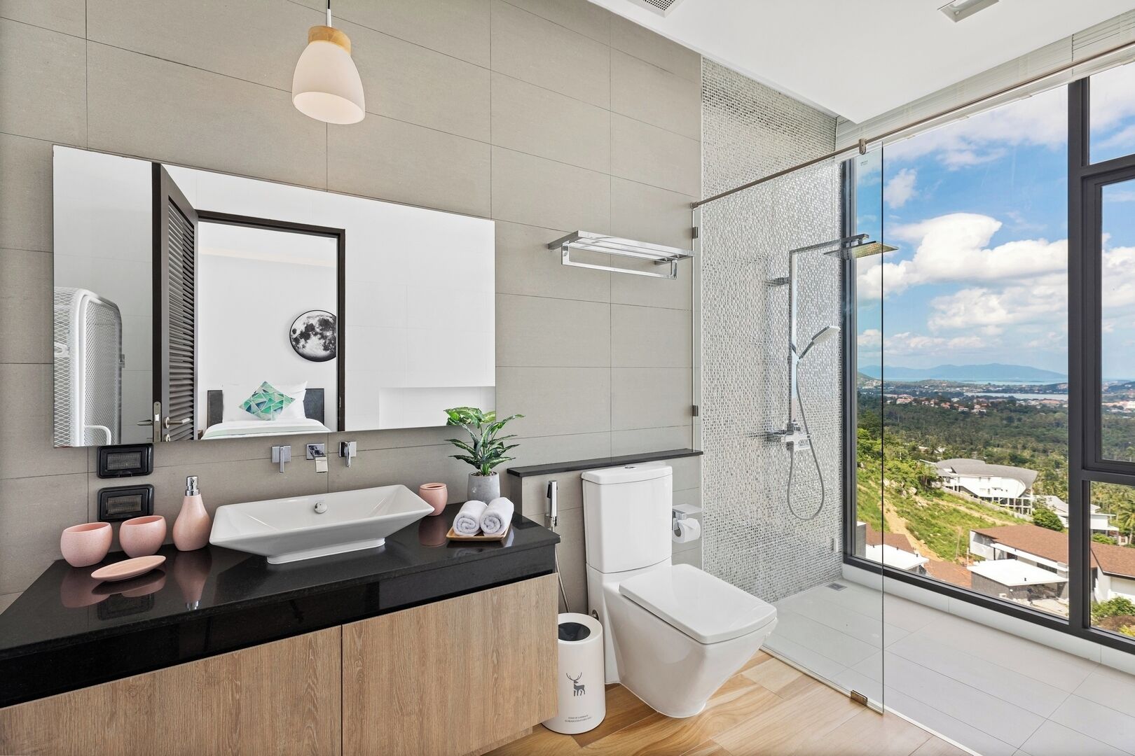 Un bagno moderno con un'ampia finestra, una doccia e un lavandino.