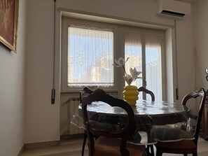 Ein Essbereich mit einem runden Tisch, Stühlen und einer Vase mit Blumen.