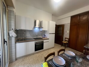 A kitchen with white cabinets, a stainless steel sink, and a built-in oven. - Sunny 2BR Apartment near Vatican • AC • Bus 98 to Centre (Roma)
