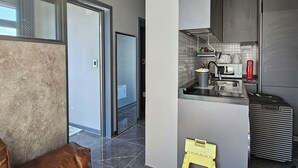 Une cuisine moderne équipée d’un réfrigérateur en acier inoxydable, d’un évier et d’une machine à café.