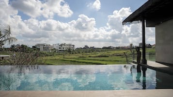 Una piscina con vistas a un paisaje verde y edificios al fondo.