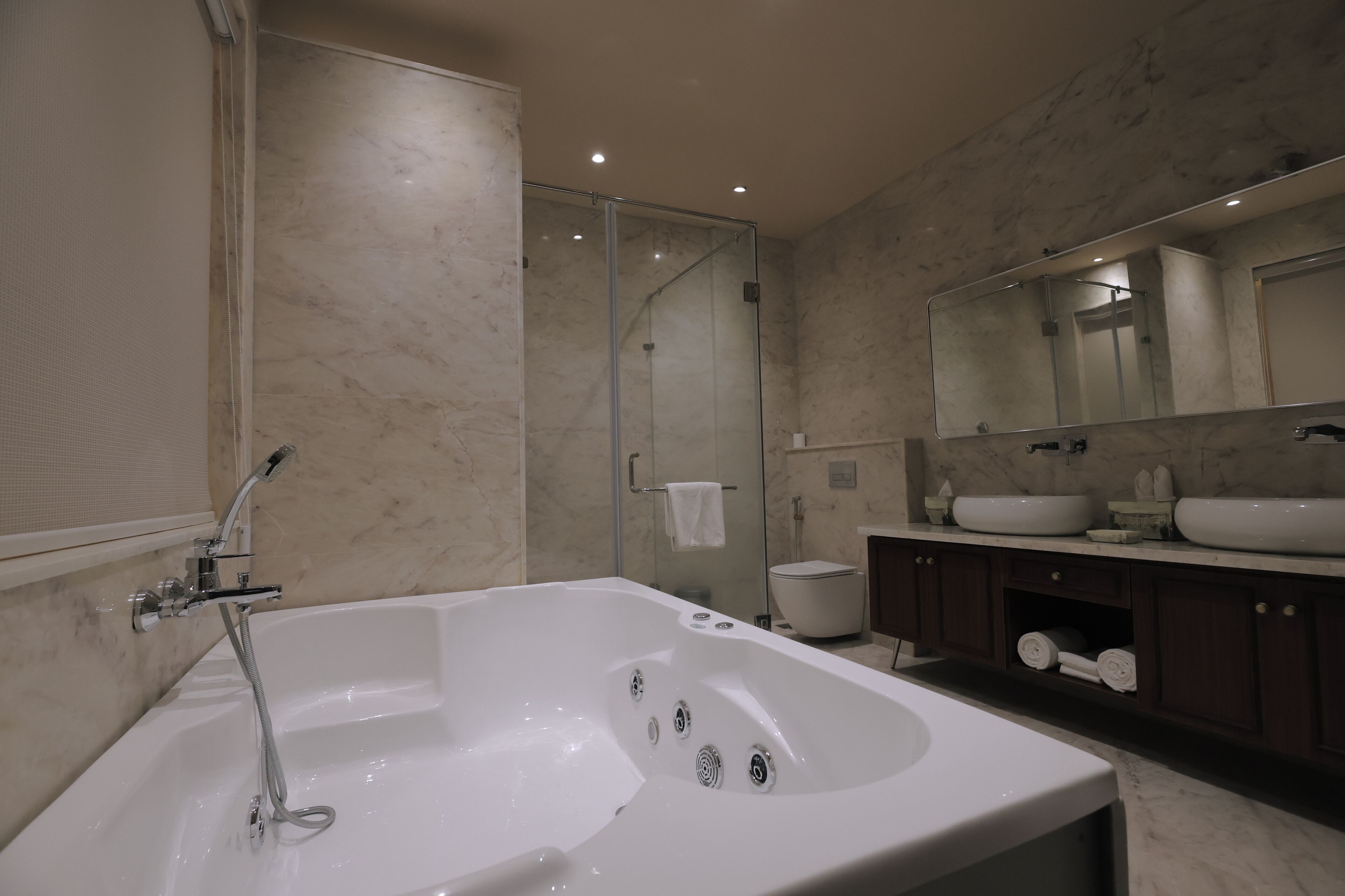 Un baño moderno con una bañera grande, una ducha con cerramiento de vidrio y un lavabo doble.