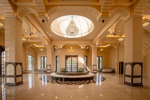 A spacious lobby with a central fountain, high ceilings, and ornate columns. - Bhanfort Palace Hotel & Resort (Chittorgarh)