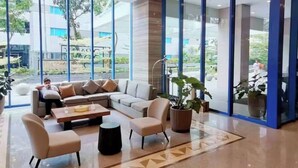 A modern lobby with a sofa set, a coffee table, and a potted plant. - Luxury Studio 38 Park Ave (Cebu City)