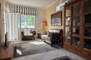 A living room with a sofa, armchair, and a cabinet with glass doors. - Casita Palmera - Altea, Costa Blanca (Altea)