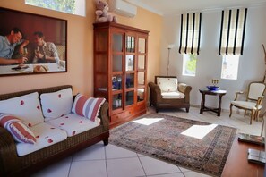 A living room with a sofa, a cabinet, a chair, a table, and a rug. - Casita Palmera - Altea, Costa Blanca (Altea)