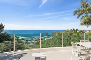 A balcony with a view of the ocean and buildings. - Rhapsody by Coast Hosting (Terrigal)