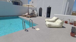 Una piscina al aire libre de temporada, sombrillas