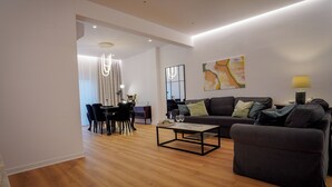 A modern living room with a dining area, featuring a sofa, coffee table, and a dining table with chairs. - To Casa Krini είναιι ένα υπέροχο διαμέρισμα στο κέντρο του Ηρακλείου (Iraklio)