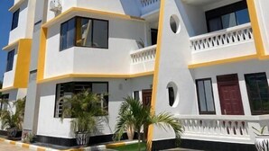 Un hotel de varios pisos con balcones, techo plano y cielo despejado.