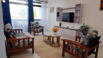 Departamento Deluxe, balcón, vista a la ciudad | Área de sala de estar | Smart TV de 32 pulgadas con canales digitales