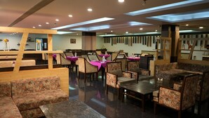 Un restaurant amb seients en cabines i taules, detalls de fusta i un disseny de sostre modern.