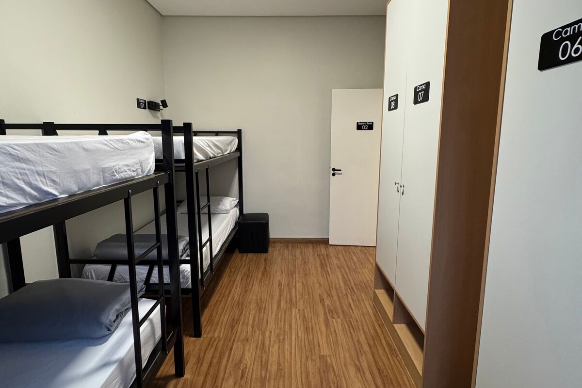 Un dormitorio con literas, un armario y una puerta con números de habitación.