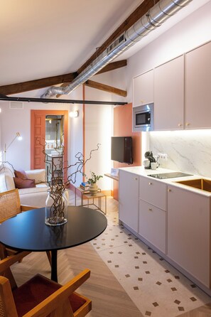 Eine moderne Küche mit eingebauter Mikrowelle, einem Spülbecken und einem Essbereich mit rundem Tisch und Stühlen.