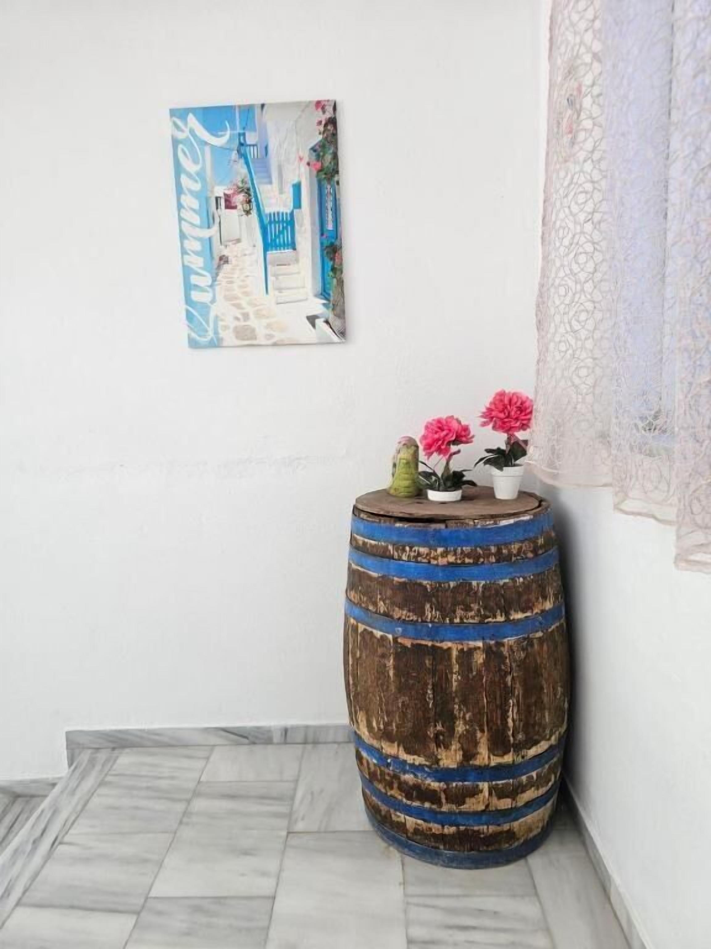 Un rincón con un barril de madera rústico, un cuadro enmarcado y un encaje de tul.
