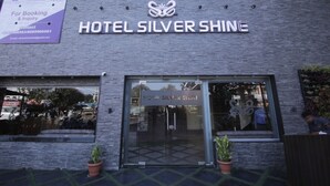 Entrada de un hotel con un letrero que dice 'HOTEL SILVER SHINE'.