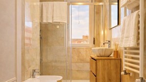 Ein modernes Badezimmer mit einer freistehenden Badewanne, einer gläsernen Dusche und einem Holzbadezimmer-Waschtisch.
