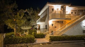 Un immeuble à deux étages doté d’un balcon, d’un escalier et d’une entrée bien éclairée.