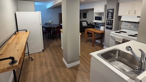 A compact kitchen with a wooden table, a built-in oven, and a white sink.