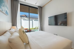Una camera d'albergo con un letto, una televisione, una finestra con tende e vista su una piscina e pannelli solari.