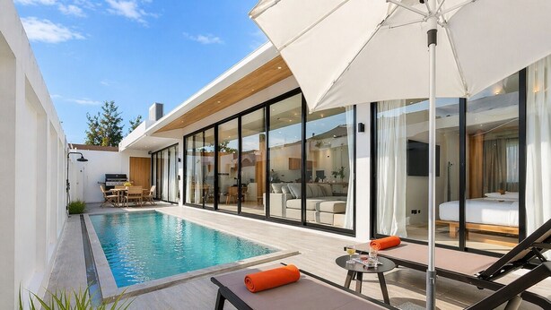 A modern outdoor pool area with lounge chairs, a table, and a large umbrella. - Seaside New 3BR Pool Villa 2 Min Walk to Bangtao Beach, Villa Belplaya Phuket (Tambon Choeng Thale)