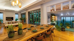 Un comedor amplio con una larga mesa de madera dispuesta para una comida, rodeado de sillas.