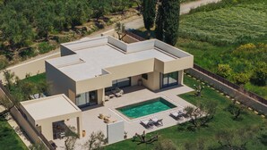 Una casa moderna amb piscina, pati i un jardí ben cuidat.